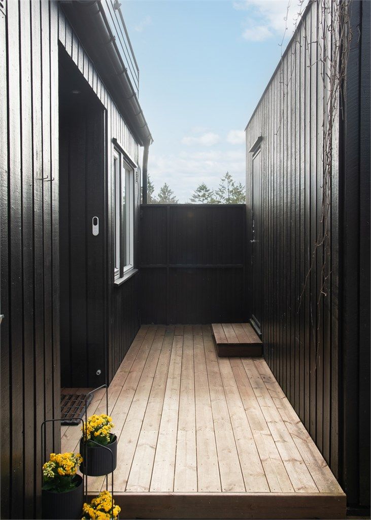 En svalgang med tredekke gir en skjermet passasje langs deler av fasaden.