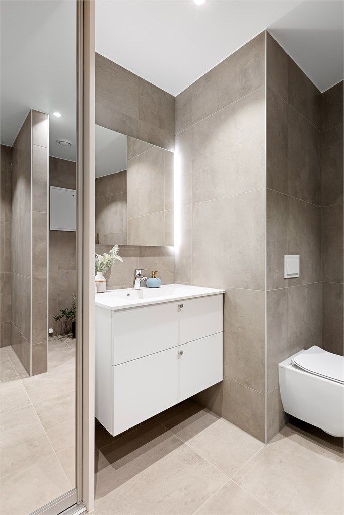 Skyvedørsgarderobe på badet som skjuler teknisk anlegg.