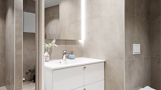 Skyvedørsgarderobe på badet som skjuler teknisk anlegg.