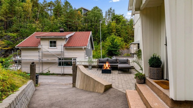 På begges sider av huset er det fine uteplasser, her ved inngangspartiet. Adkomst til boligen er asfaltert og forstøttningsmurer er nylig satt opp.