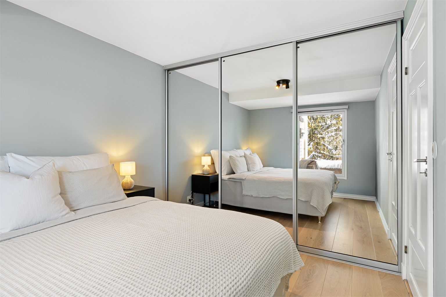 En stor skyvedørsgarderobe med speilfronter gir rikelig med oppbevaringsplass og en god romfølelse.