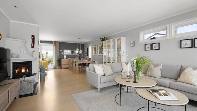 Åpen og luftig stue. Ved spisebord er det skyvedør ut til terrasse og hage mot sør-øst.