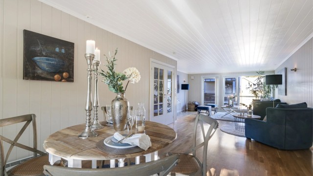 Åpen stue/kjøkkenløsning innredet med spisemøblement.