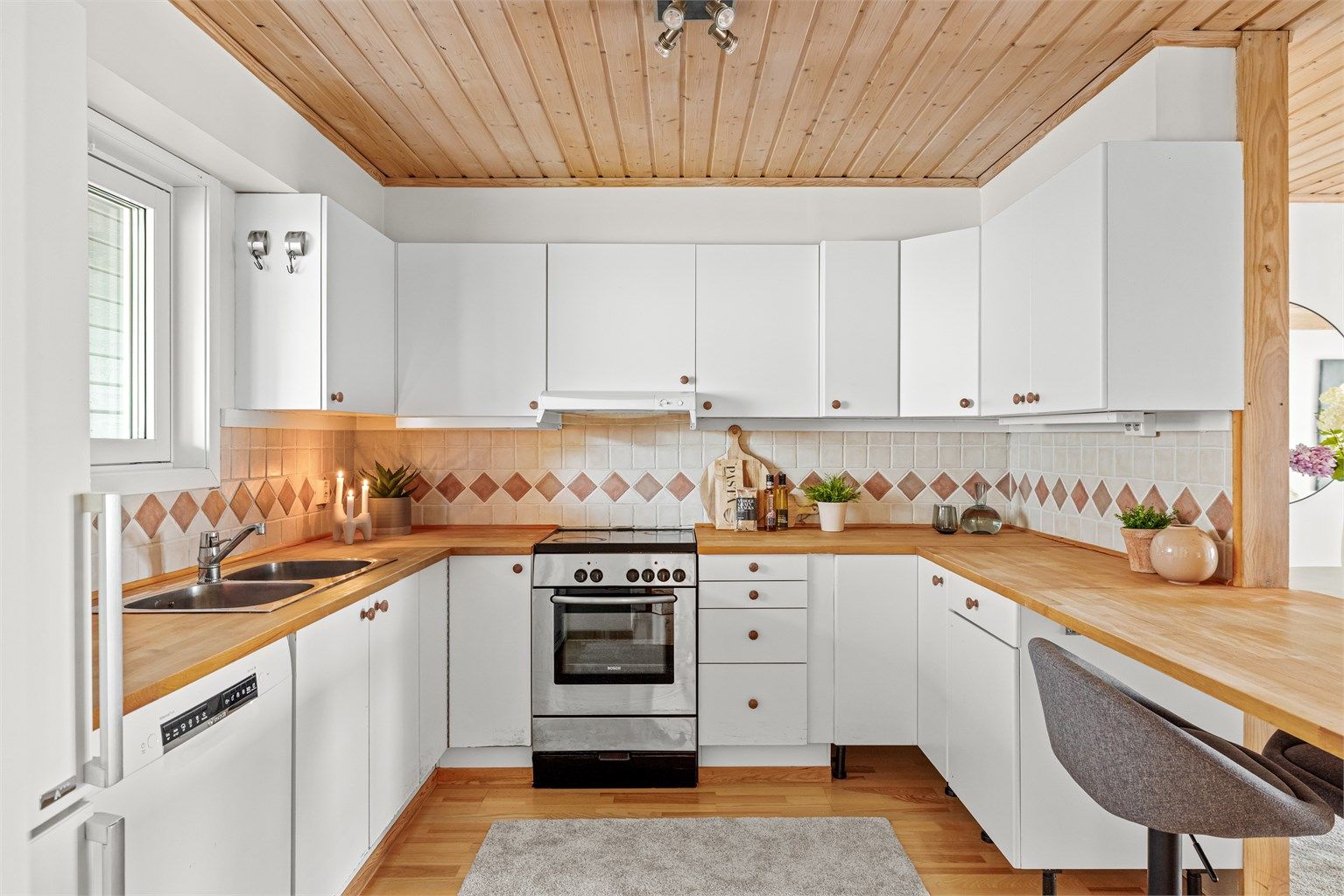 Kjøkkenet har en åpen løsning mot stuen og er utstyrt med gode arbeidsflater. Oppvaskmaskin, komfyr og frittstående kombiskap medfølger.