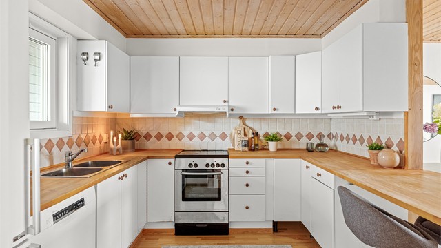 Kjøkkenet har en åpen løsning mot stuen og er utstyrt med gode arbeidsflater. Oppvaskmaskin, komfyr og frittstående kombiskap medfølger.