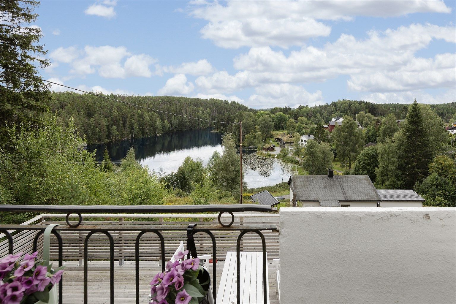 Fra balkongen er det fri utsikt over vannet og skogen.