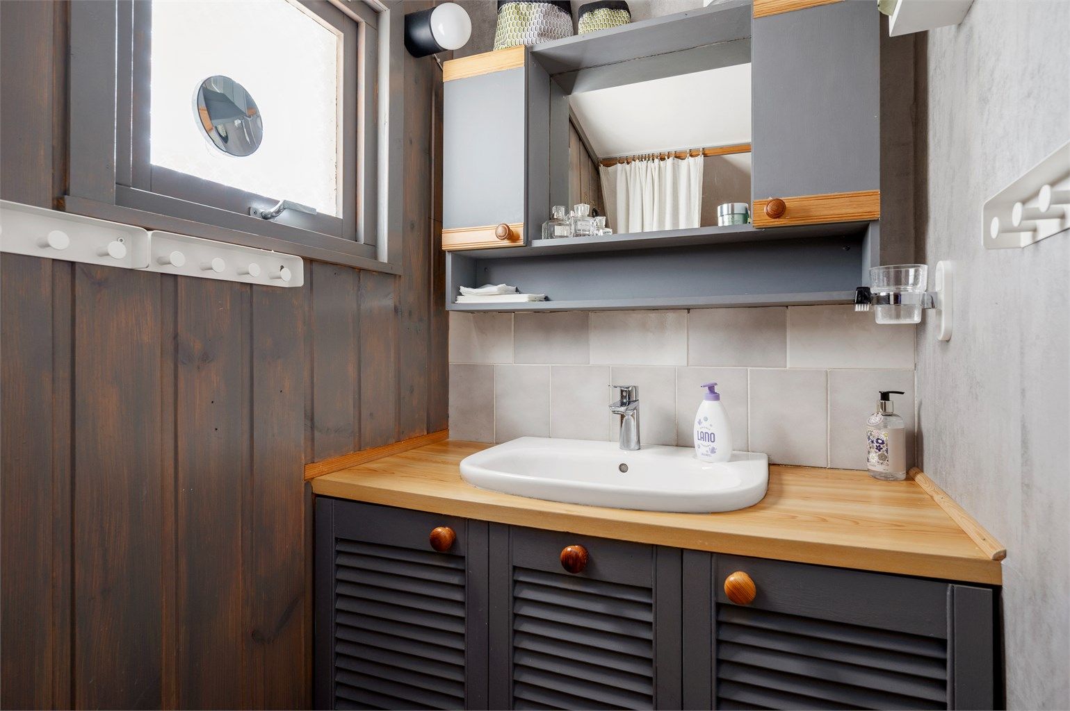 Det er etablert et praktisk servantskap med overskap og speil i forbindelse med gangen. 