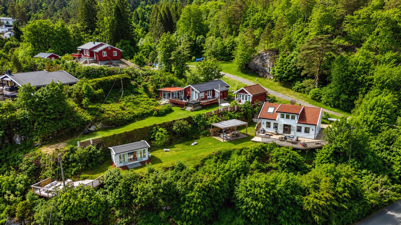 Eiendommen på over 1 mål består av hytte, utestue og bod med et samlet bruksareal på totalt 100 m², og 136 m² terrasser, samt pergola med utekjøkken.

