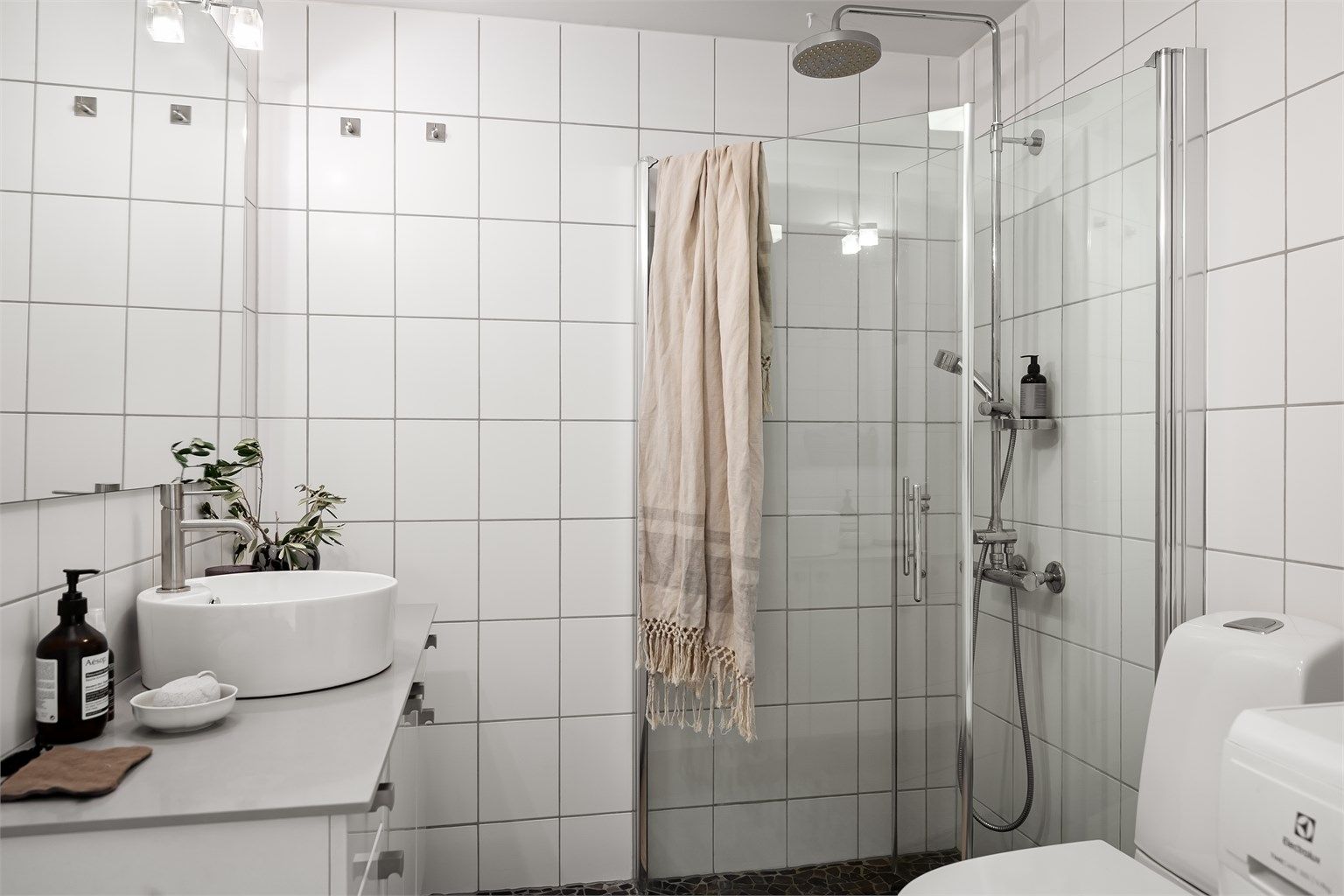 Gulvstående toalett og dusjhjørne med innfellbare glassdører, og dusjsett med rainshower