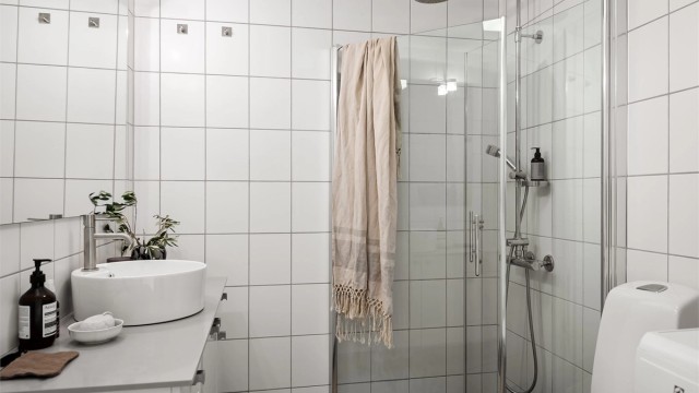 Gulvstående toalett og dusjhjørne med innfellbare glassdører, og dusjsett med rainshower