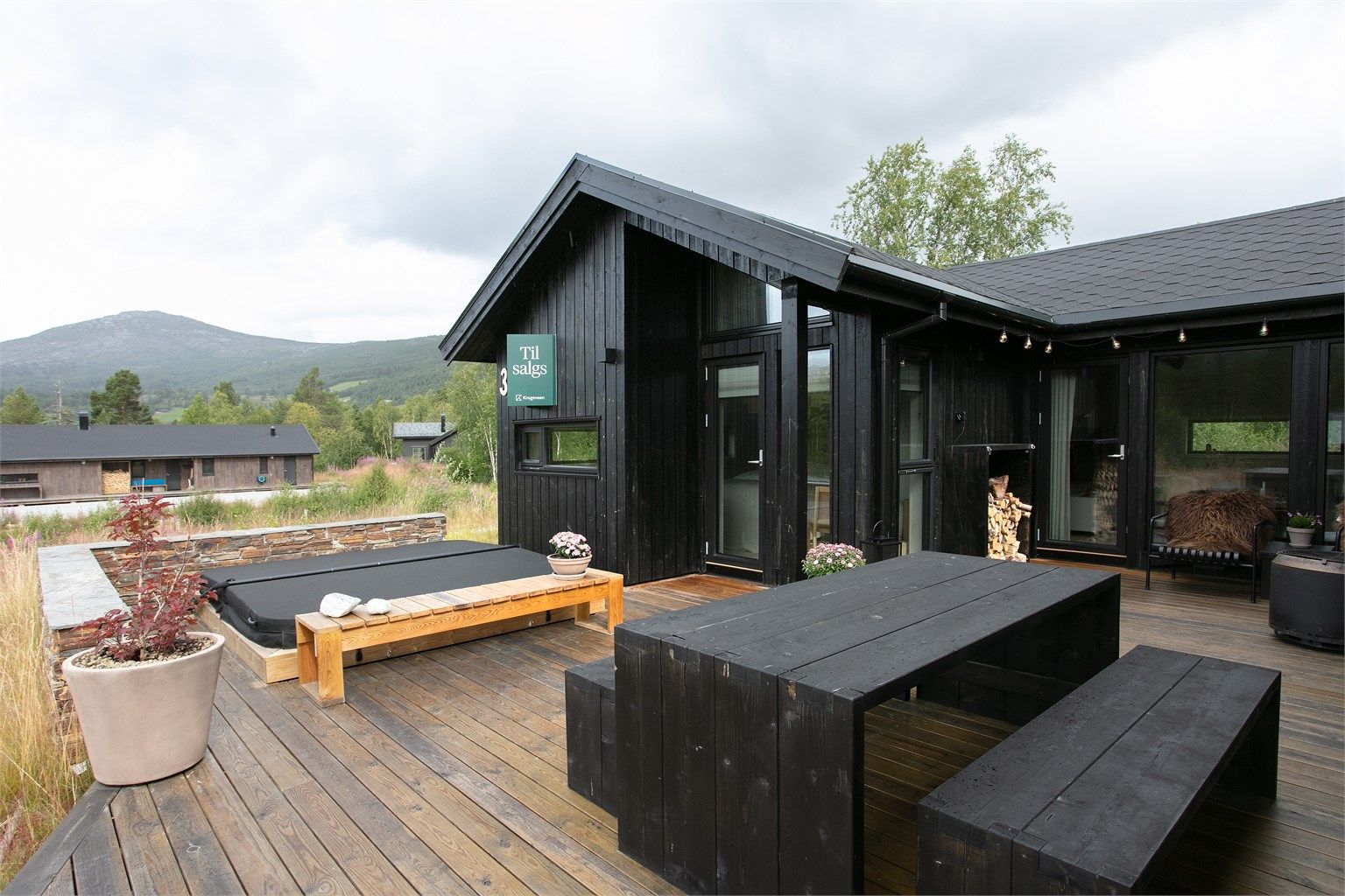 Jacuzzi er nedsenket i terrassen og rammet inn med natursteinmur.