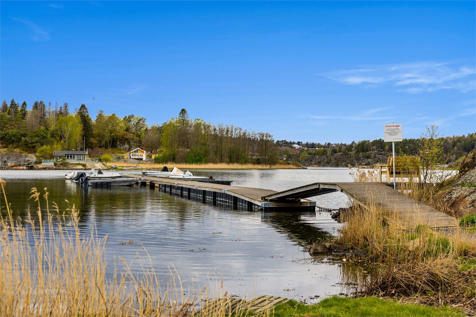 Parkeringsplass ved bryggeanlegg på landsiden. Eiendommen disponerer en båtplass i Strand bryggelag.