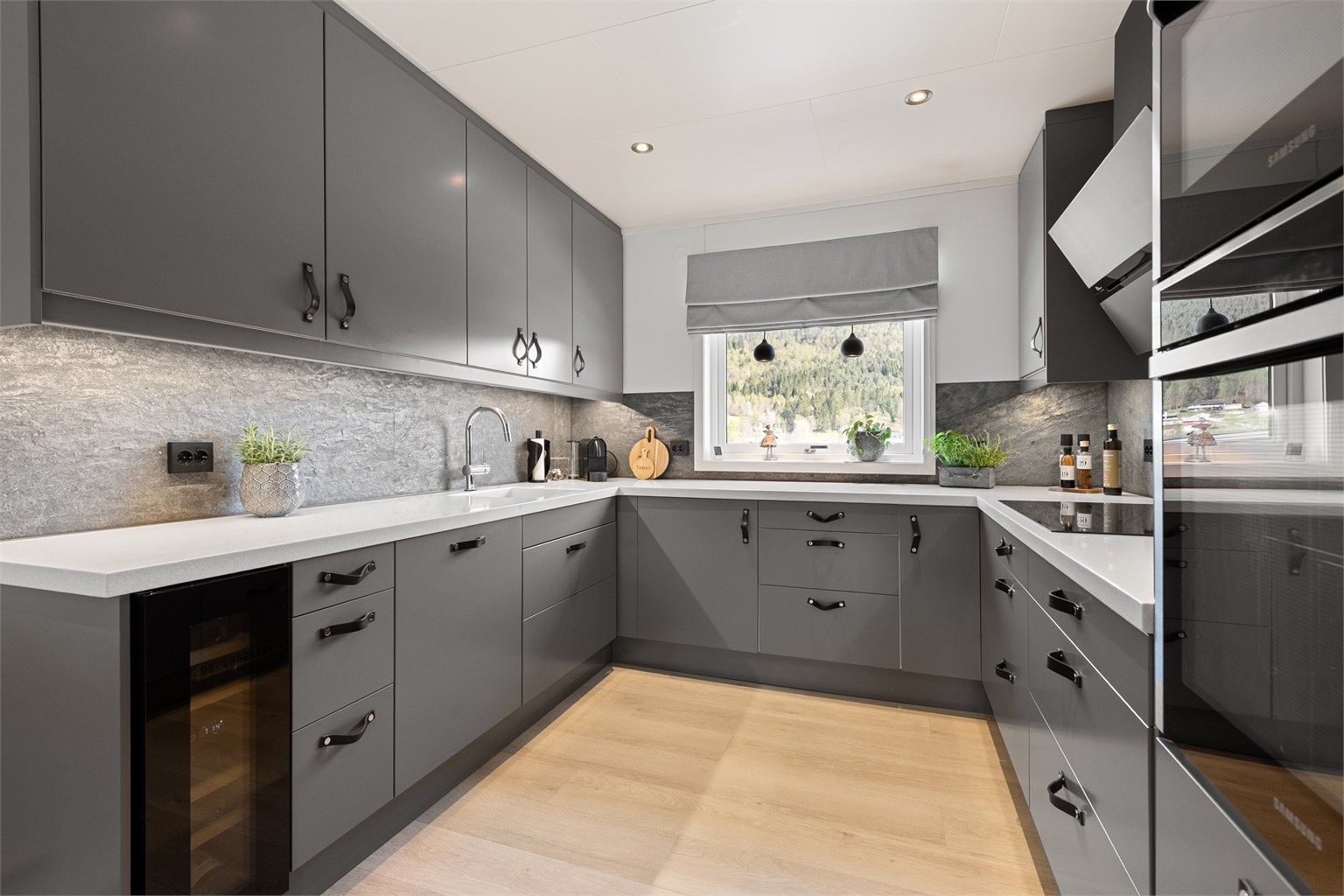 Innredningen har glatte fronter, benkeplate i plastkompositt og et frittstående vinskap som medfølger.