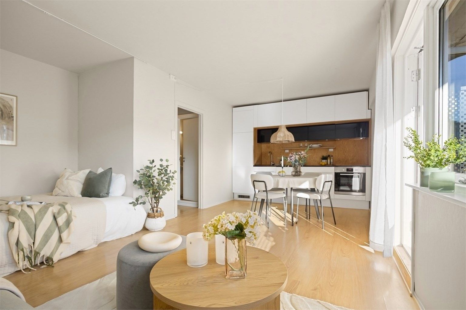 God planløsning med plass til både spisebord, seng og sofadel. Det er åpen løsning mellom stue og kjøkken.