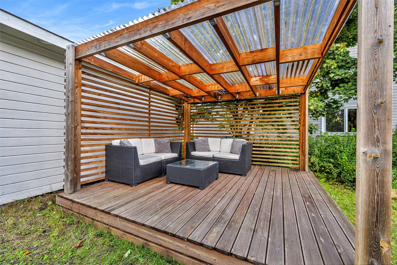 Pergola med tak hvor det er god plass til utemøbler og grill