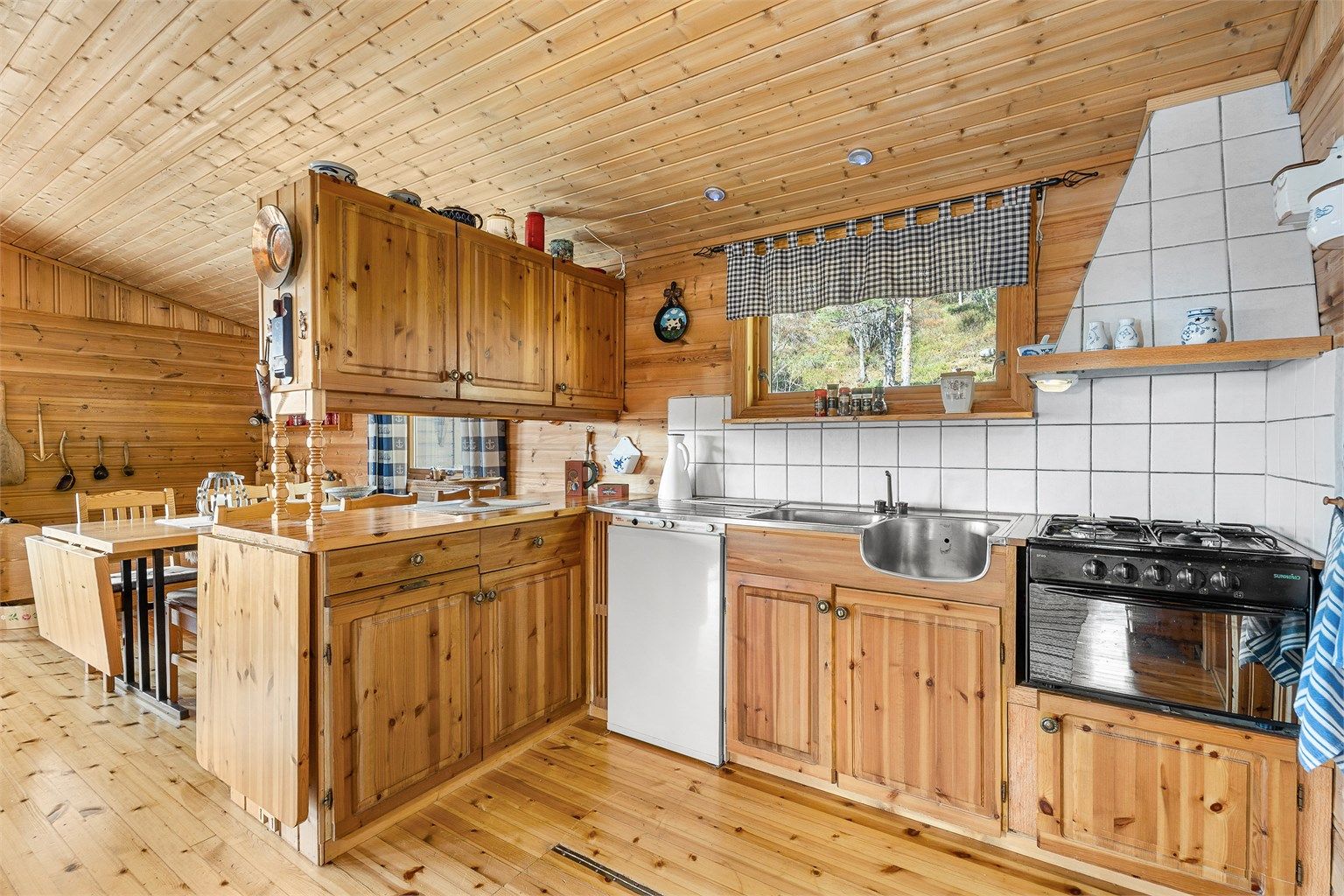 Kjøkken med innredning fra byggeår med god skapplass og funksjonell arbeidsflate. Kjøleskap og ovn med fire koketopper medfølger i følge selger. 