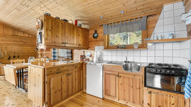 Kjøkken med innredning fra byggeår med god skapplass og funksjonell arbeidsflate. Kjøleskap og ovn med fire koketopper medfølger i følge selger.