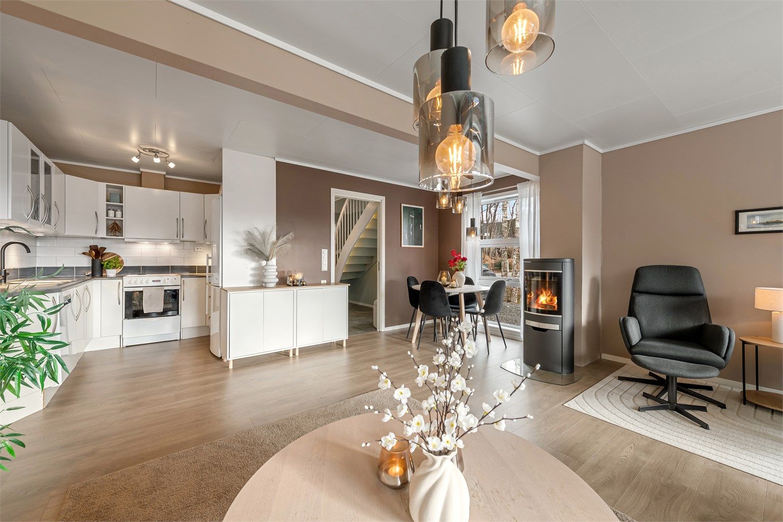 Den åpne løsningen mellom stue og kjøkken skaper en sosial og luftig atmosfære.