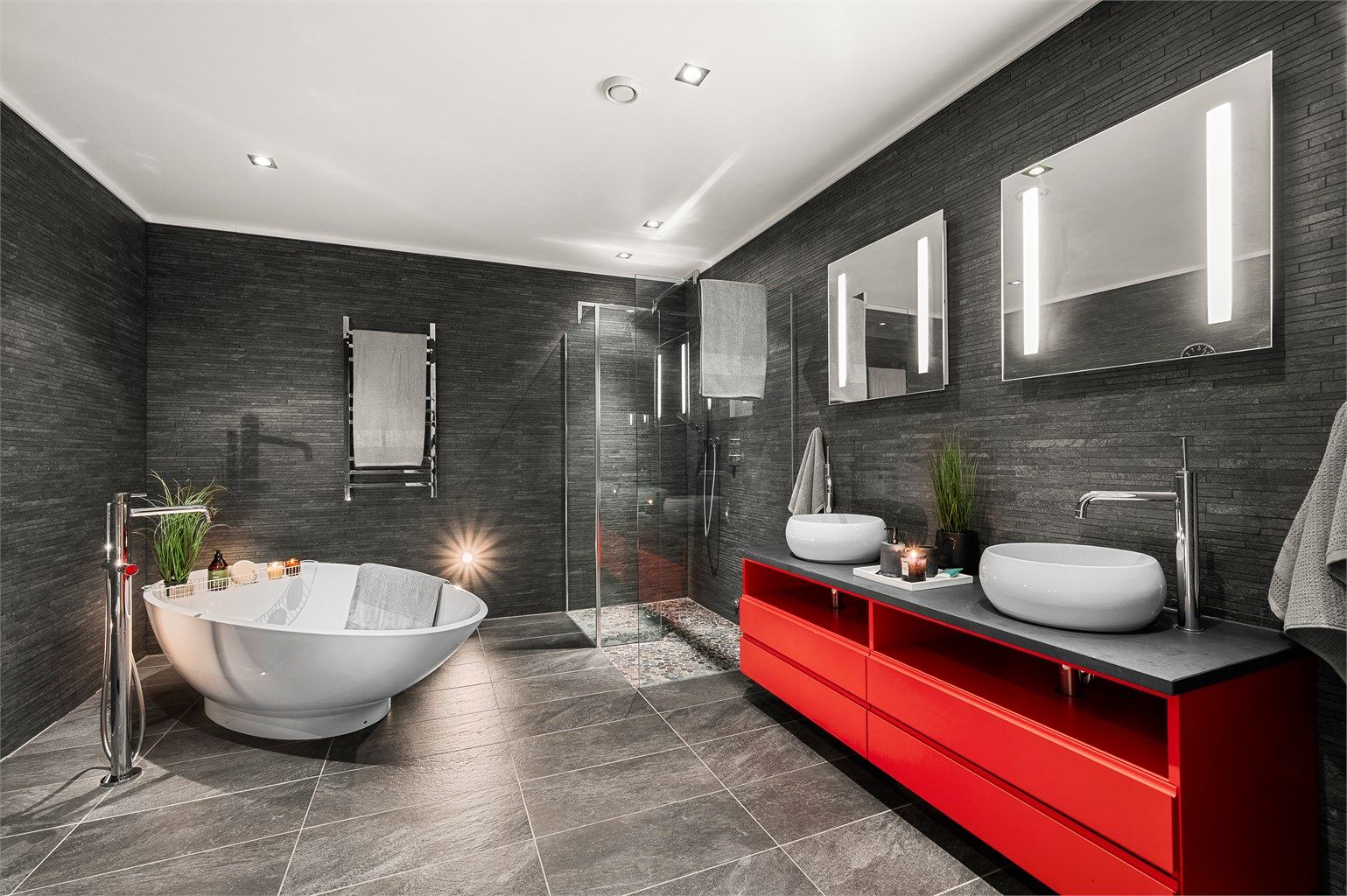 Eksklusivt og romslig en-suite bad  med plassbygde løsninger, dobbel servant, badekar, dusjsone og en hotellinspirert atmosfære.