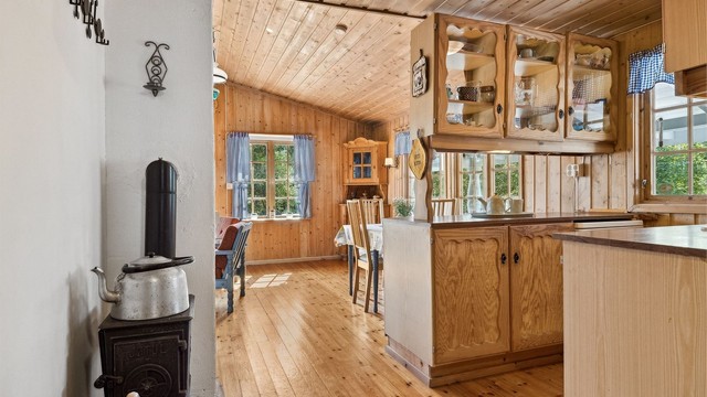 Lunt kjøkken med åpen løsning mot stue.