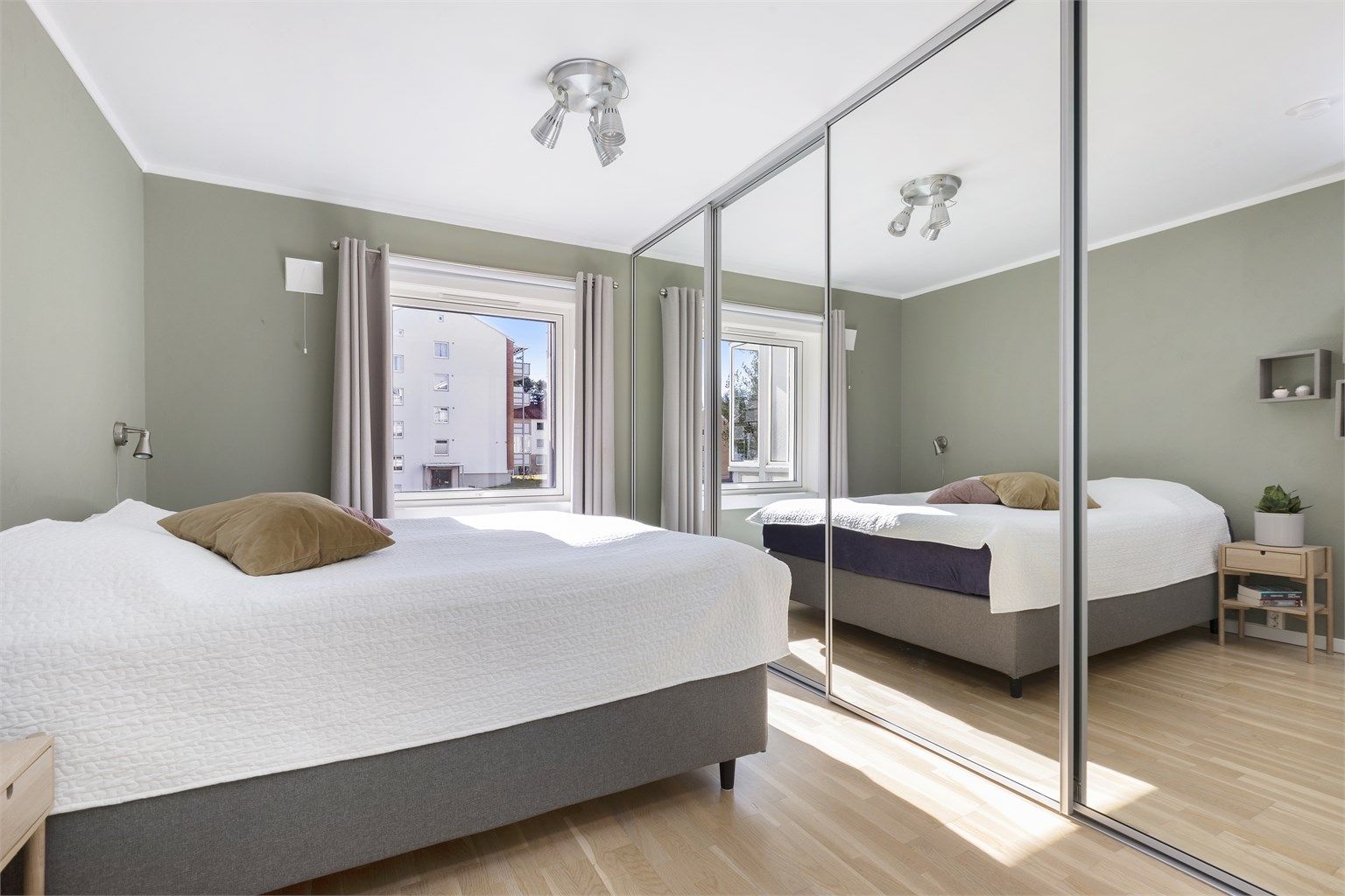 En stor skyvedørsgarderobe med speilfronter gir rikelig med oppbevaringsplass.