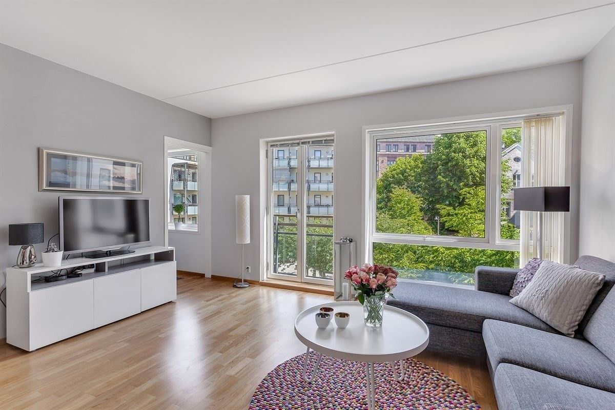 Lys og luftig stue med store vindusflater og fransk balkong.