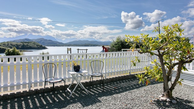 Sitteplass ved stakittet med utsikt over fjorden.