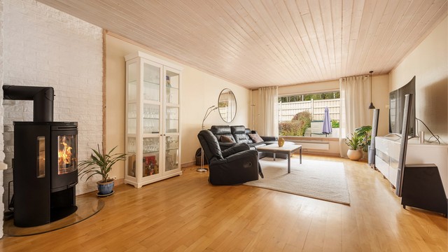 Romslig stue i første etasje med vedovn med glassdør. Foto: Martine Eren Jacobsen