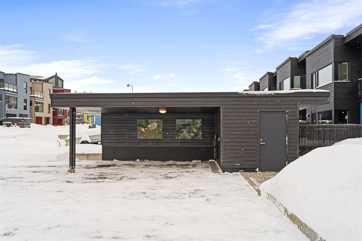 Carport med bod finner du like utenfor inngangsdøra til boligen