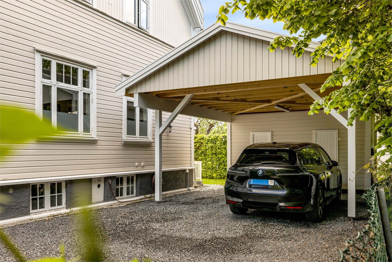 Medfølgende parkeringsplass med el-lader i carport bygget ny i 2025 på tomten.