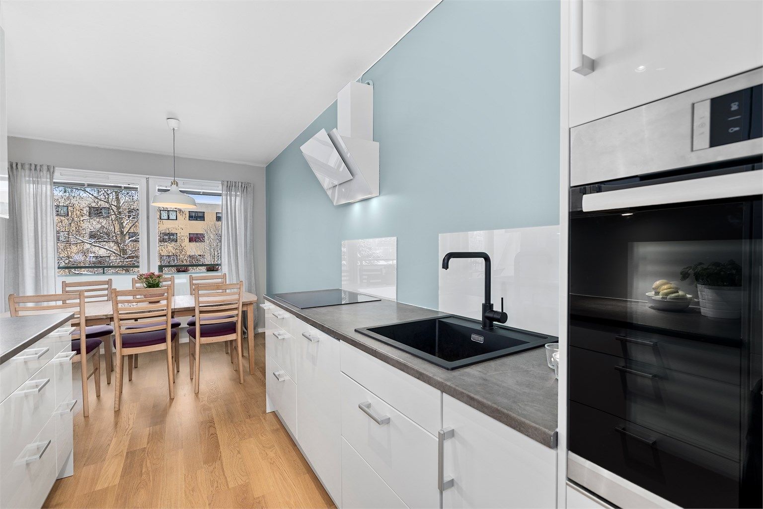 Kjøkkeninnredning fra 2016 med benkeplater av laminat. Praktisk glassplate er montert over benken for enkelt renhold.