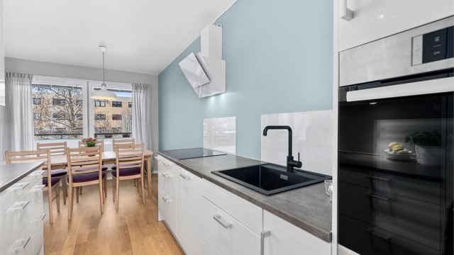 Kjøkkeninnredning fra 2016 med benkeplater av laminat. Praktisk glassplate er montert over benken for enkelt renhold.