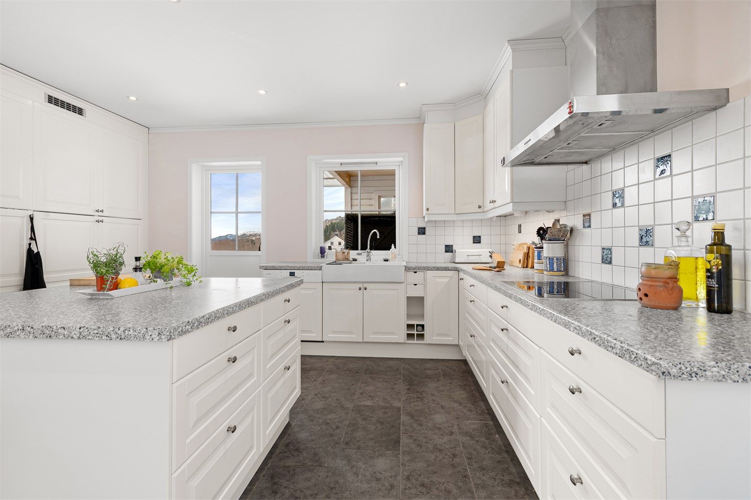 En stor kjøkkenøy gir ekstra arbeidsflate og fungerer som et sosialt midtpunkt i rommet.