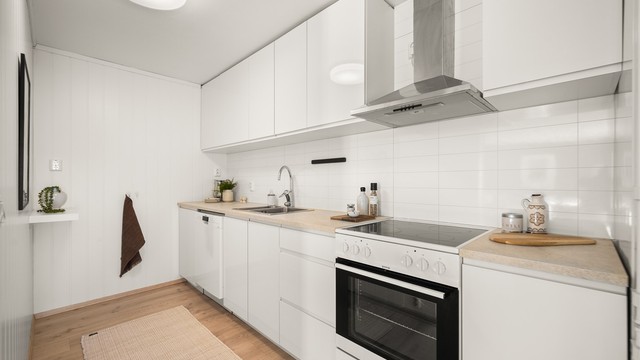 Kjøkkenet i den minste delen, er fra 2018 og har en moderne Kvik-innredning med glatte, hvite fronter.