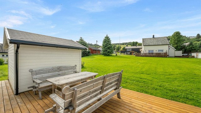 Ved garasjeområdet er det etablert en hyggelig terrasse med sittegruppe og utsyn over de store grøntarealene.