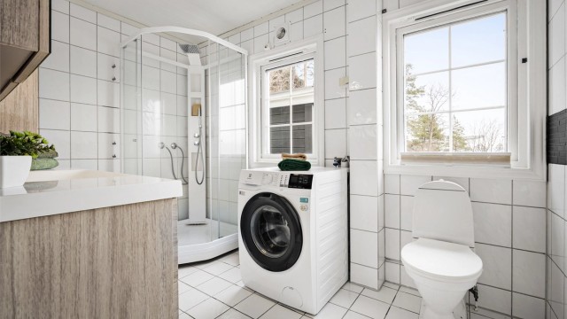 Dusjkabinett og gulvstående toalett. Opplegg for vaskemaskin.