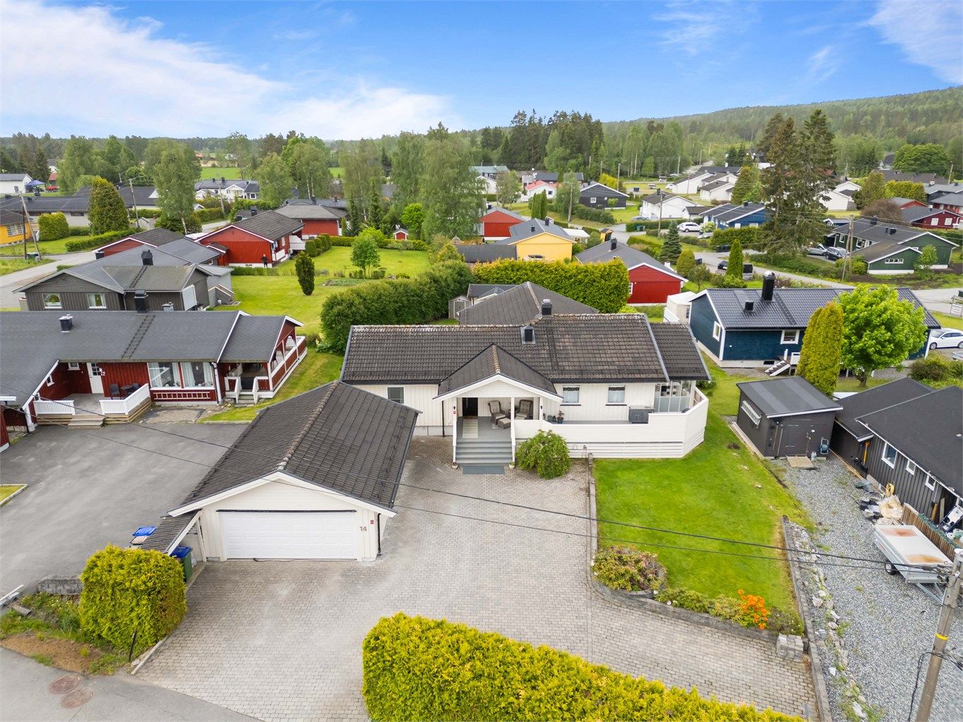 Eiendommen har en steinbelagt gårdsplass og en romslig, lettstelt hage.