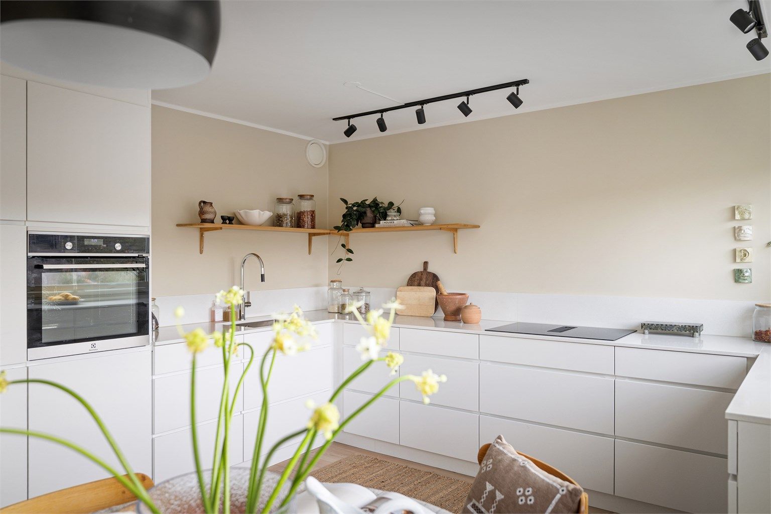 Stort og veldisponert kjøkken med moderne innredning fra Kvik (2024) med benkeplater i kompositt og integrerte kvalitetshvitevarer fra AEG/Electrolux.