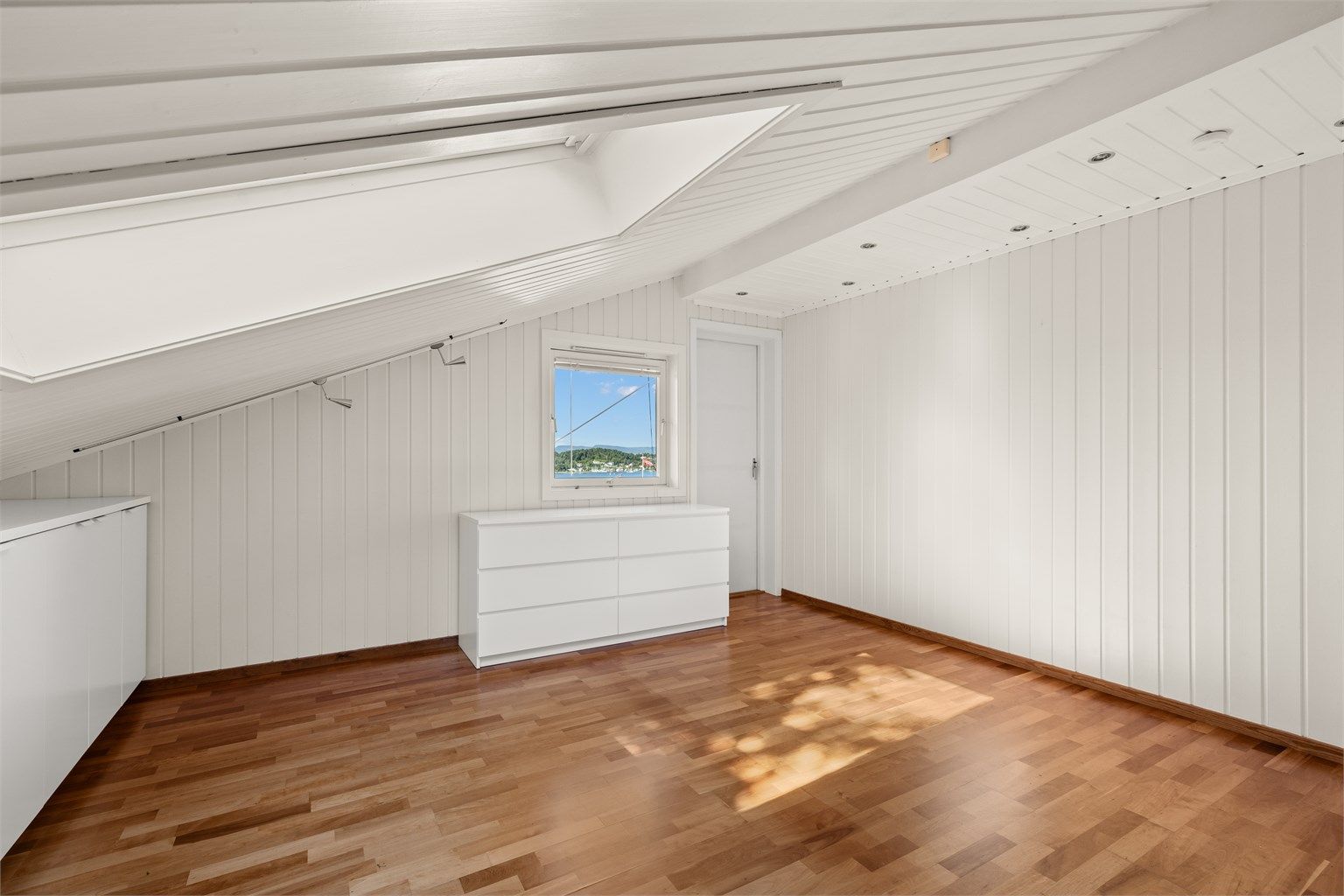 Rommet har parkett på gulvet og malt panel på vegger og i himling.