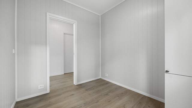 Soverommet har laminatgulv og panelte overflater.