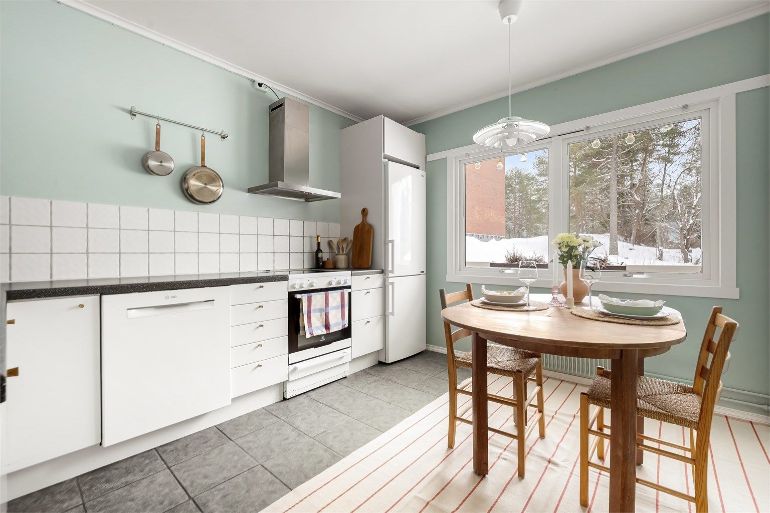 Kjøkkeninnredningen har slette fronter og slitesterke benkeplater av laminat.