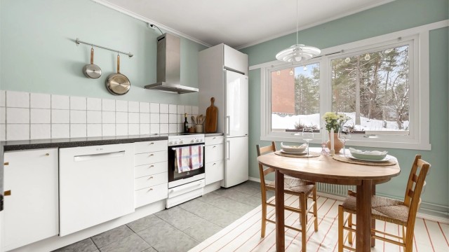 Kjøkkeninnredningen har slette fronter og slitesterke benkeplater av laminat.