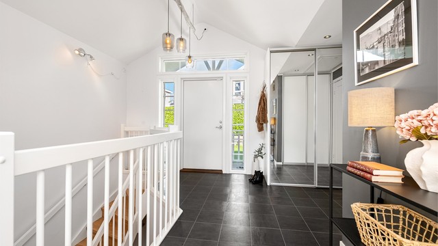 Entré med flislagt gulv, god takhøyde og skyvedørsgarderobe med speilfronter.
