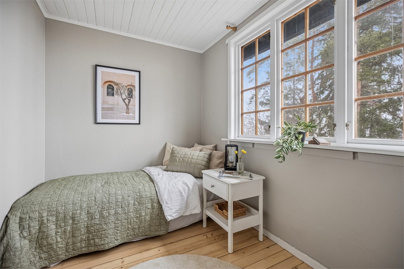 Soverom nr. 3 er lyst og innbydende med malt panel i himling og slipte tregulv.