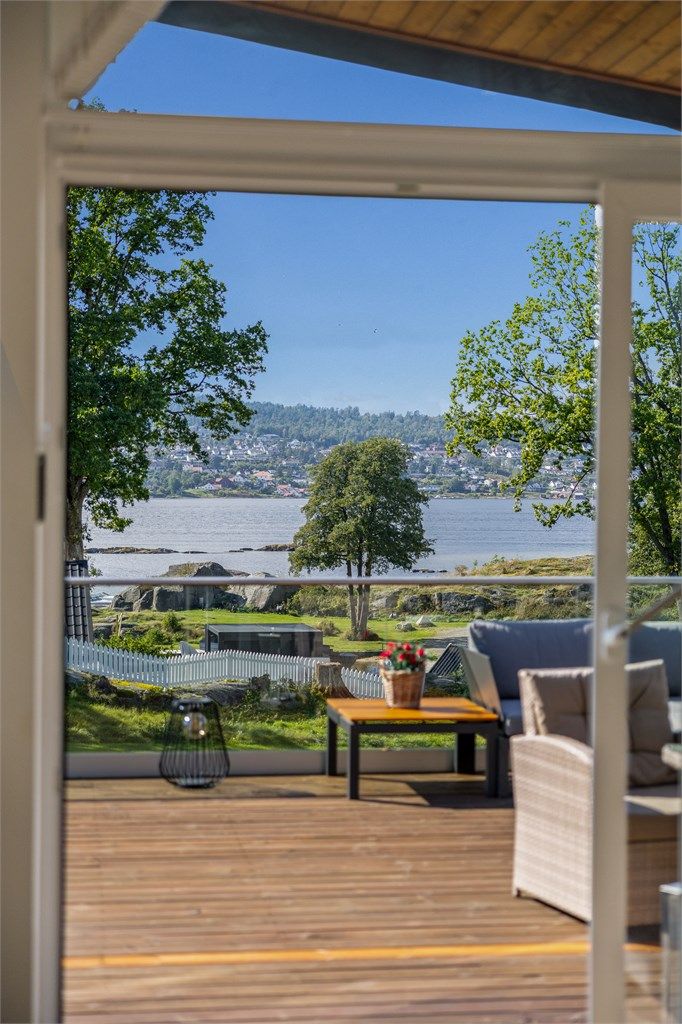 I stua består gavlveggen mot sjøen av store vindusflater og en hev- skyvedør.