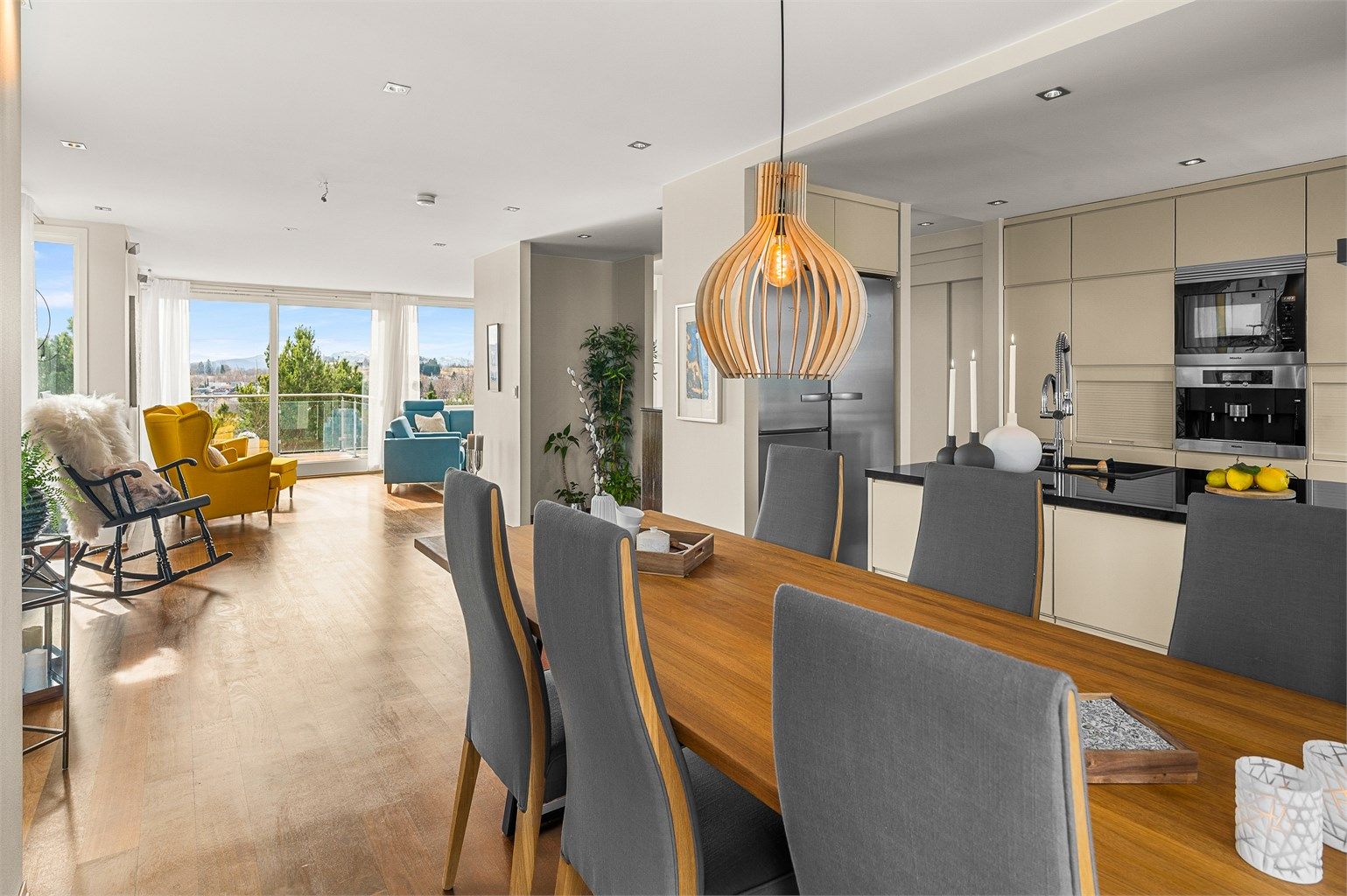 Fra spisestuen og kjøkkenet er det en fin flyt videre mot stuen, noe som understreker boligens åpne og sosiale planløsning.