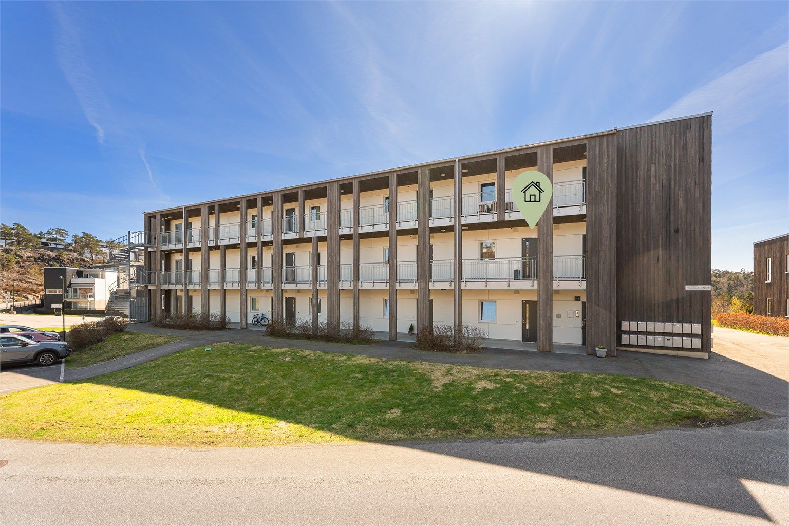 Leilighet markert fra fremside med gjesteparkering
