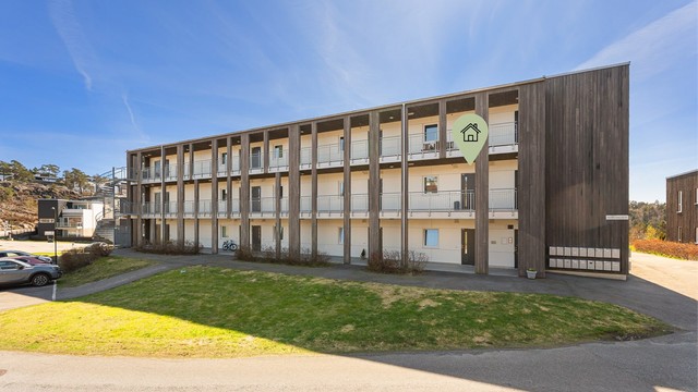 Leilighet markert fra fremside med gjesteparkering