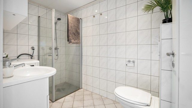 Flislagt bad med gulvvarme. Downlights i himlingen. Innredet med vegghengt servantinnredning.