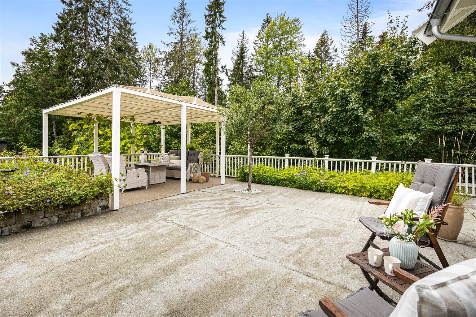 En paviljong på ca. 18 m² skaper en lun og definert sone på uteplassen.